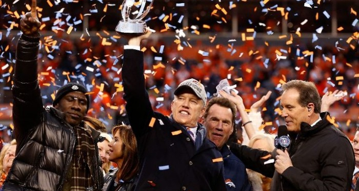 General Manager and Executive Vice President of Football Operation for the Denver Broncos John Elway holds up the Lamar Hunt Trophy with former Bronco Terrell Davis after defeating the New England Patriots in the AFC Championship game at Sports Authority