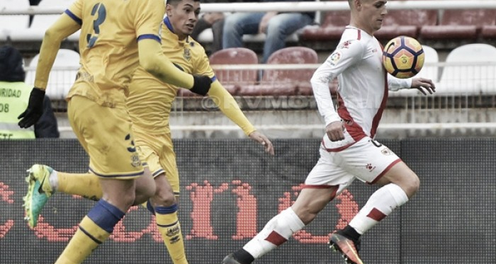 Álex Moreno llevándose un balón frente a dos rivales. Fotografía: Rayo Vallecano S.A.D.