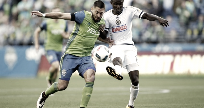 Joshua Yaro jostles with Clint Dempsey during MLS action last season. (Photo credit: USA Today)
