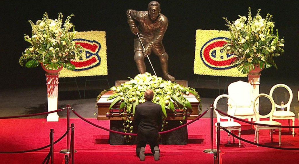 Guy Lafleur kneels in front of Jean Beliveau's casket in Montreal.