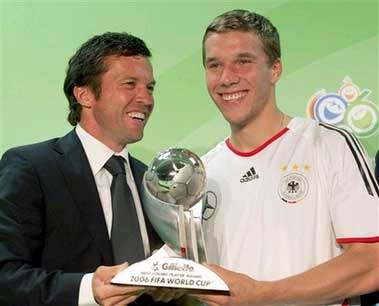 Podolski posando junto a Lothar Matthaeus con su trofeo de mejor jugador joven del Mundial de 2006