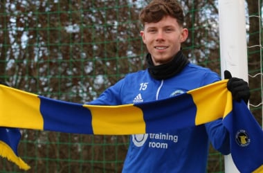 New signing Mitchell Roberts holds up a scarf upon joining the National League side on loan for the remainder of the season. (Photo @DickyKing00)