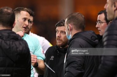 BURSLEM, ENGLAND - JANUARY 18: Referee James Bell explains to both managers that the goal posts were wonky and not upright and needed to be repaired as he suspends play during the Sky Bet League Two match between Port Vale and Salford City at Vale Park on January 18, 2022 in Burslem, England. (Photo by Matthew Ashton - AMA/Getty Images)