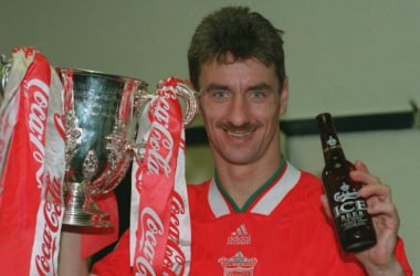 Ian Rush con uno de las muchas Copas de la Liga que ganó en su mano derecha mientras sostiene con la Izquierda una cerveza Carlsberg, uno de los patrocinadores más icónicos del Liverpool. | Foto: Liverpool FC.